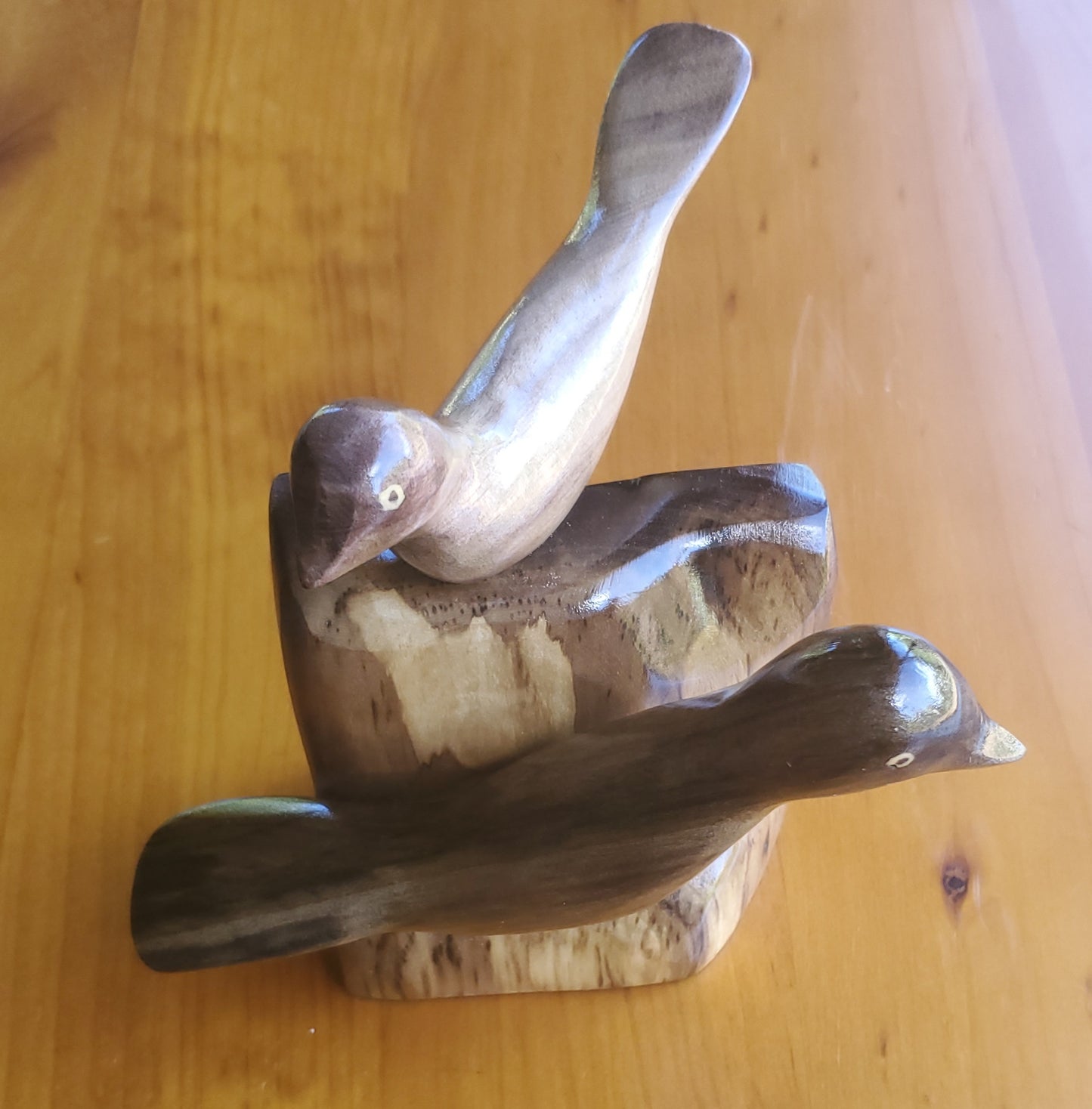 Pájaros tallados a mano en madera de burau local - en un soporte