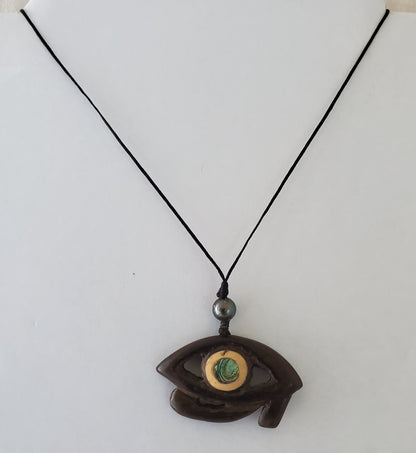 Oeil d'Isis sculpté à la main en bois de Tau local avec perle noire de Tahiti et ormeau